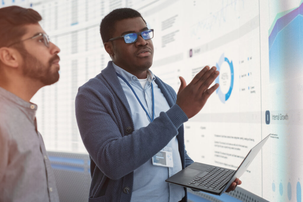 Vendia for Data Analytics Teams - Two men working in front of a screen that showcases different charts and graphs